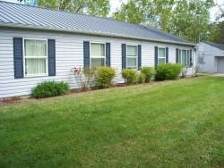 A row of windows that are part of a public housing building. There are bushes and grass in front.