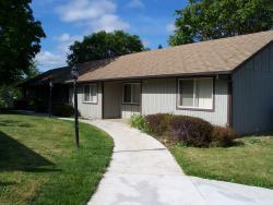 A public housing building with a walkway and grass in front.