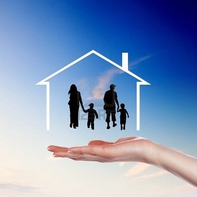 A hand holding up a family inside the outline of a house